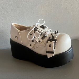 Y2K platform shoes feature gothic bone-inspired accents & a buckle strap 7.5